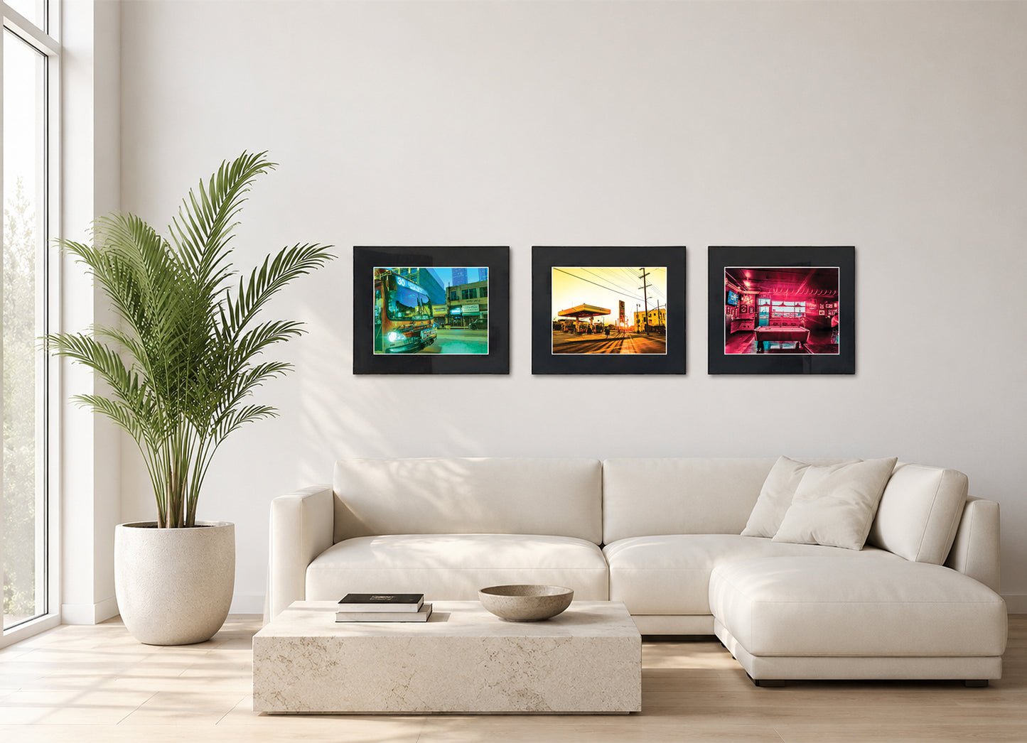 Three framed fine art photography prints displayed as a triptych gallery wall above a sofa with plant.