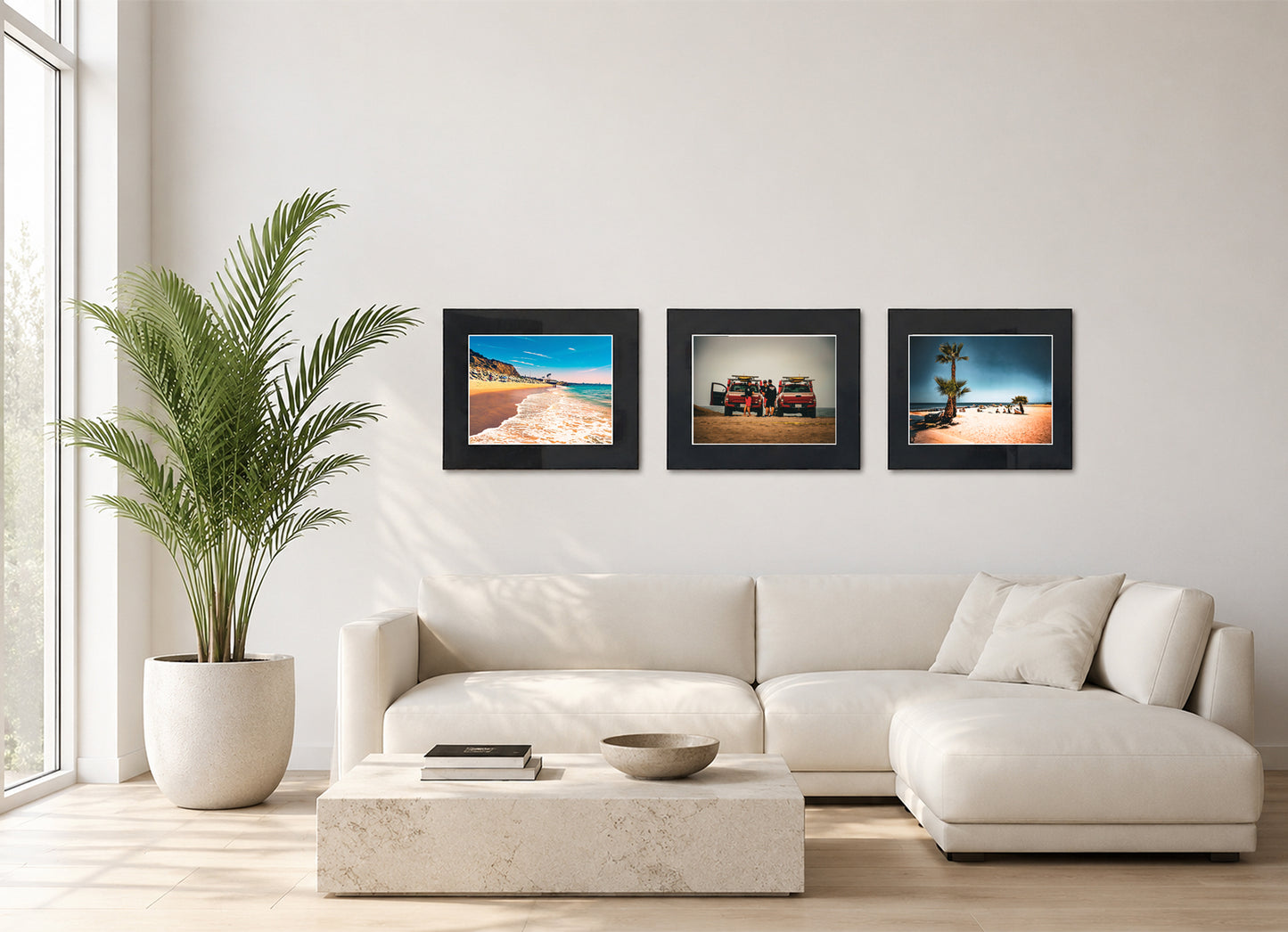 Three framed fine art photography prints displayed as a triptych gallery wall above a sofa with plant.