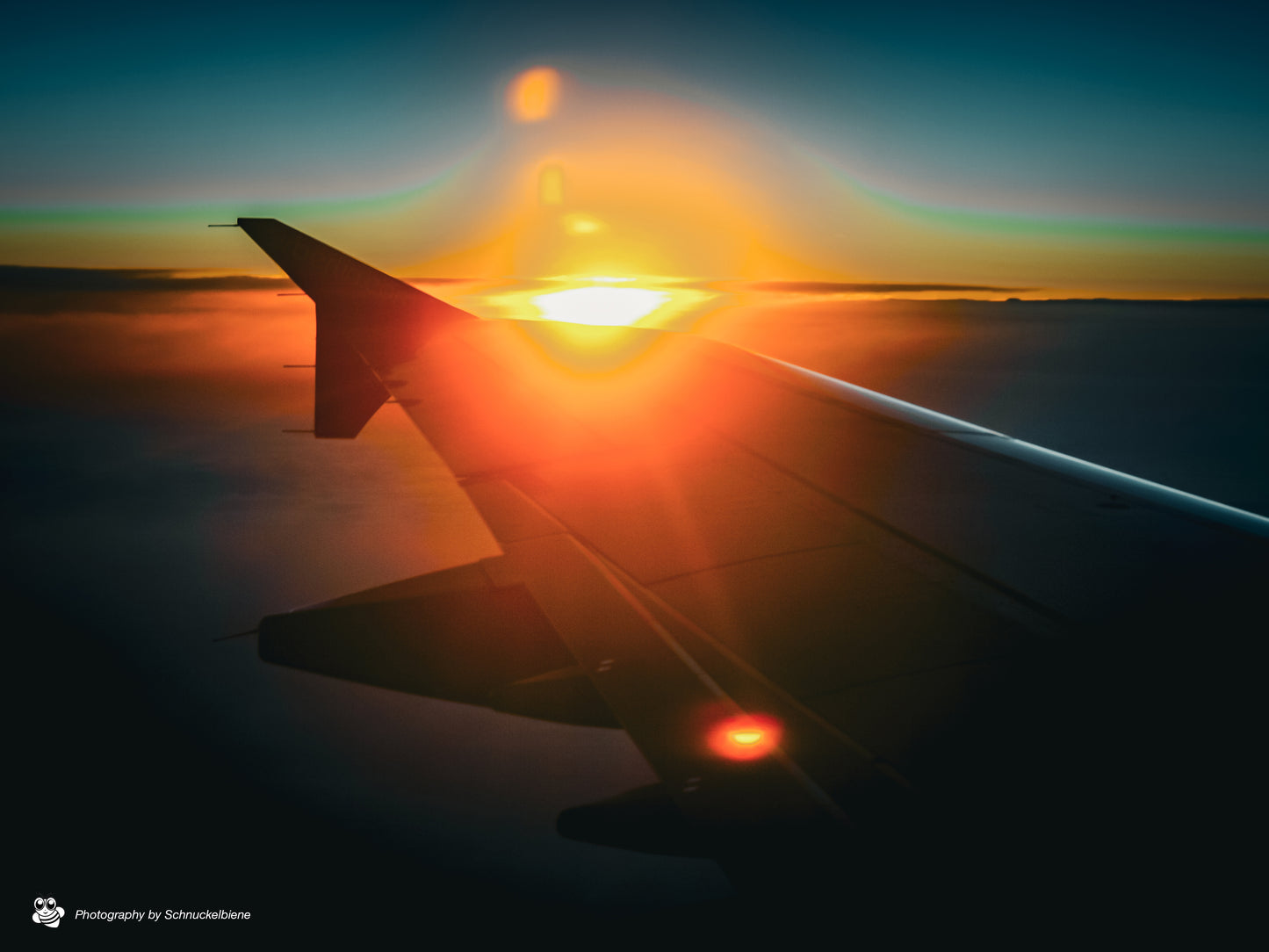 Airplane wing above the clouds during sunset on the way to Ibiza