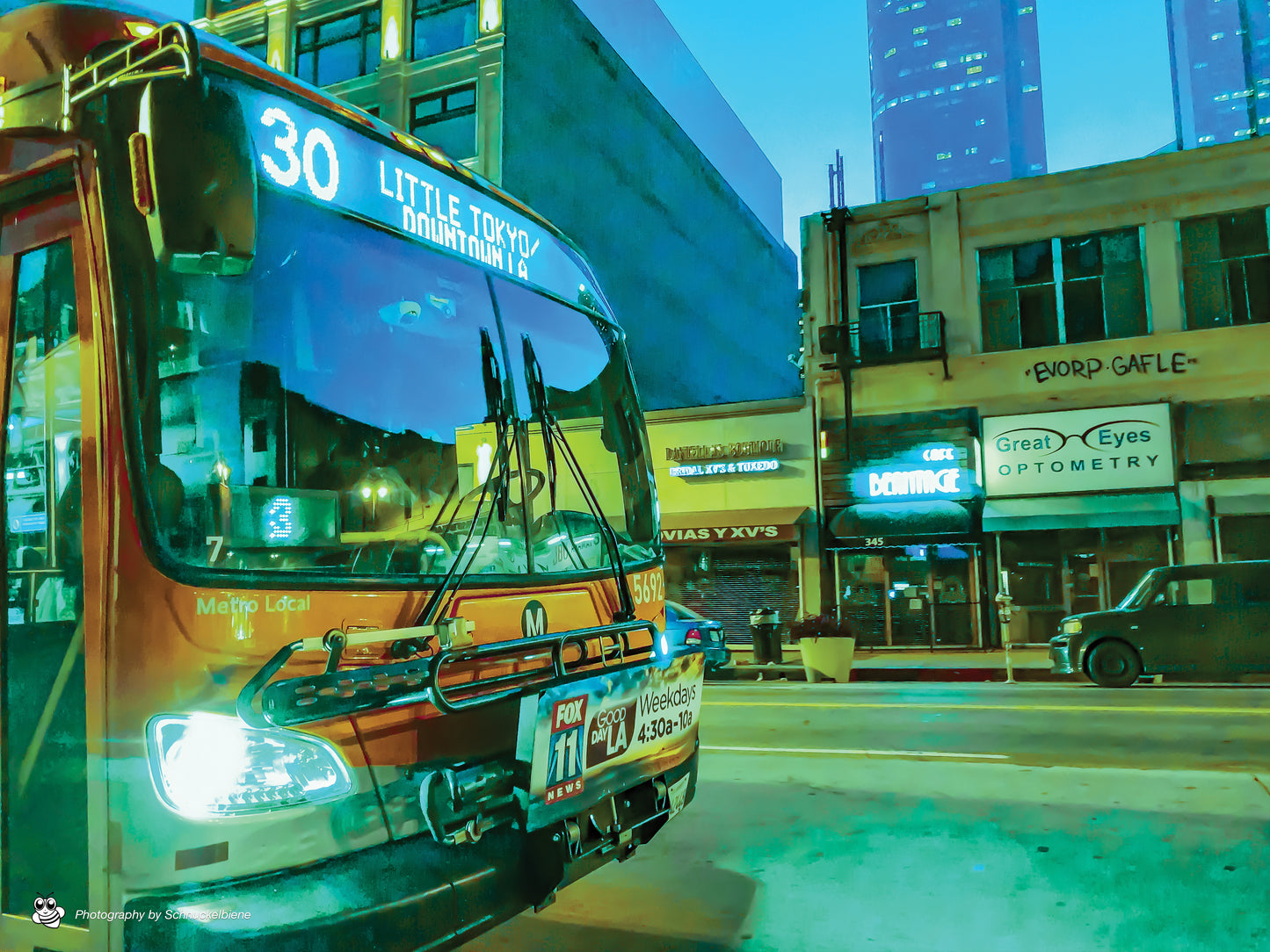 City bus in Downtown Los Angeles in direction to Little Tokyo passing between buildings on a quiet street
