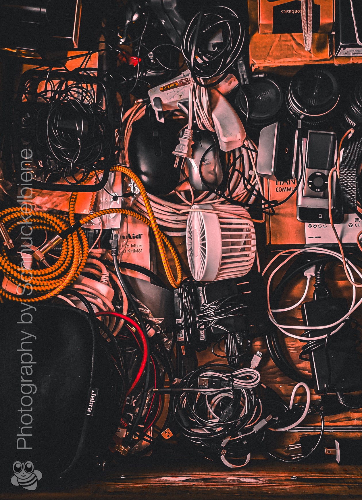 Fine art photo of an electronics drawer filled with tangled cables, tech gear, and everyday devices – ideal wall art for creative or studio spaces.