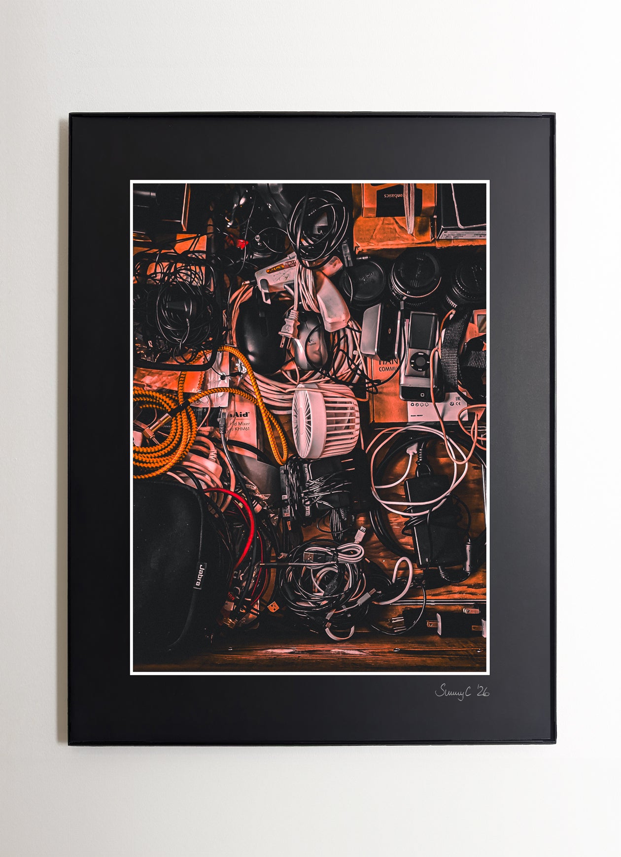 Fine art photo of an electronics drawer filled with tangled cables, tech gear, and everyday devices – ideal wall art for creative or studio spaces
