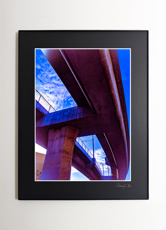 Fine art photo of a purple-lit freeway bridge in Downtown Los Angeles at night, showcasing urban architecture and city atmosphere
