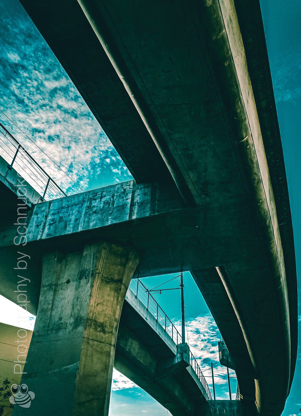 Fine art photo of a turquoise-lit freeway bridge in Downtown Los Angeles at night, showcasing urban architecture and city atmosphere