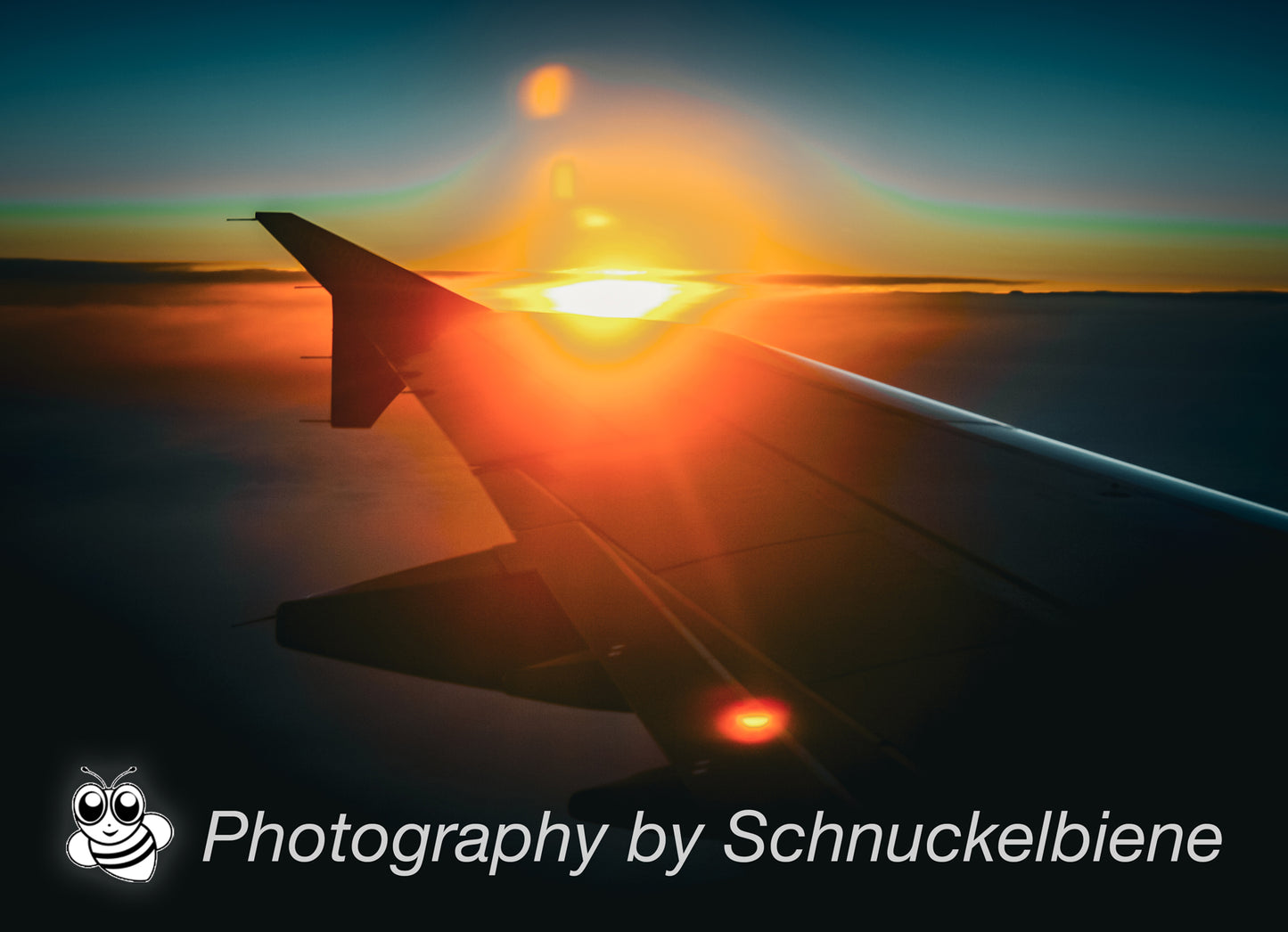 Framed artwork of an airplane wing with sunset in the background on a blue sky