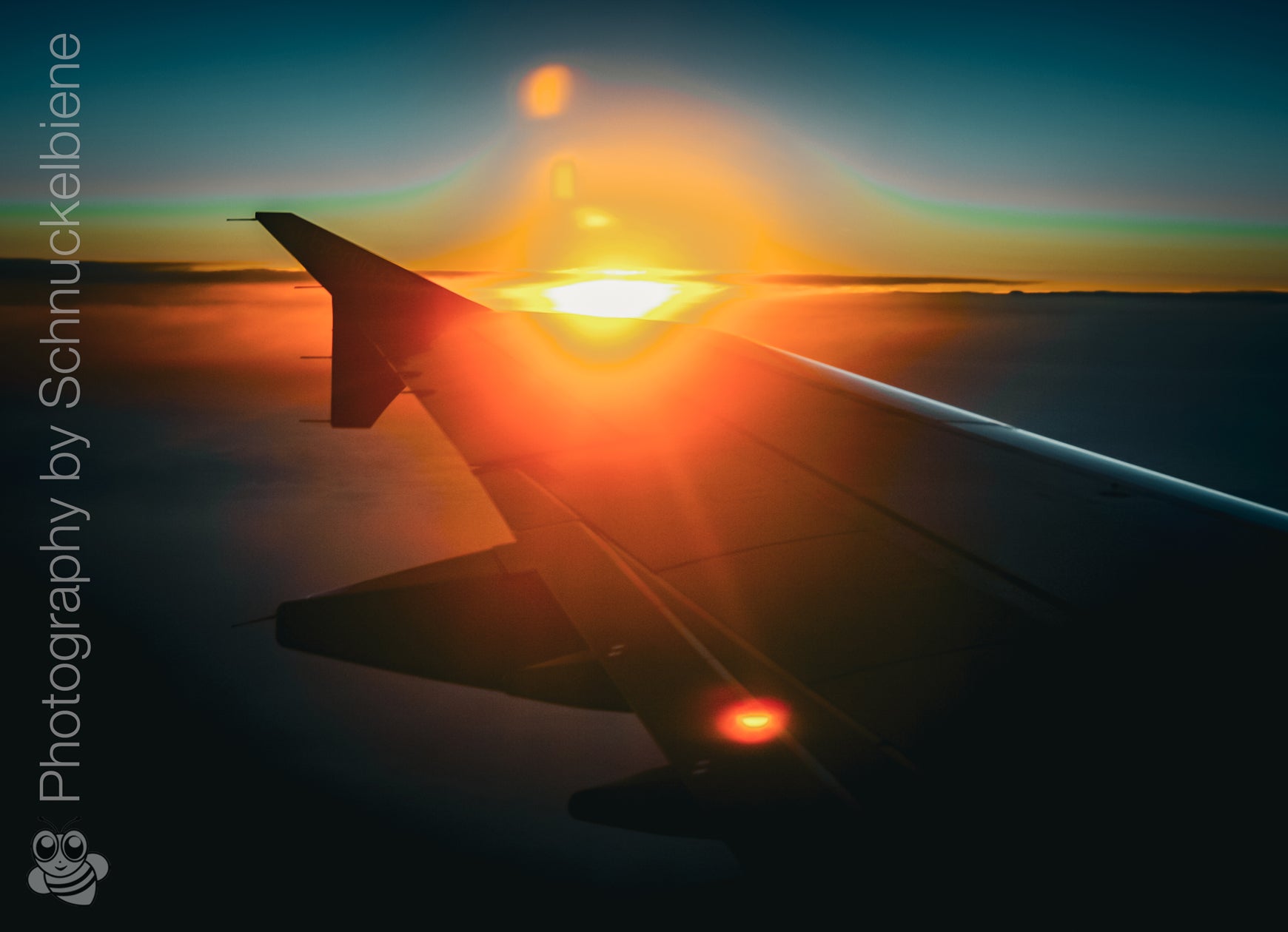 Framed artwork of an airplane wing with sunset in the background on a blue sky