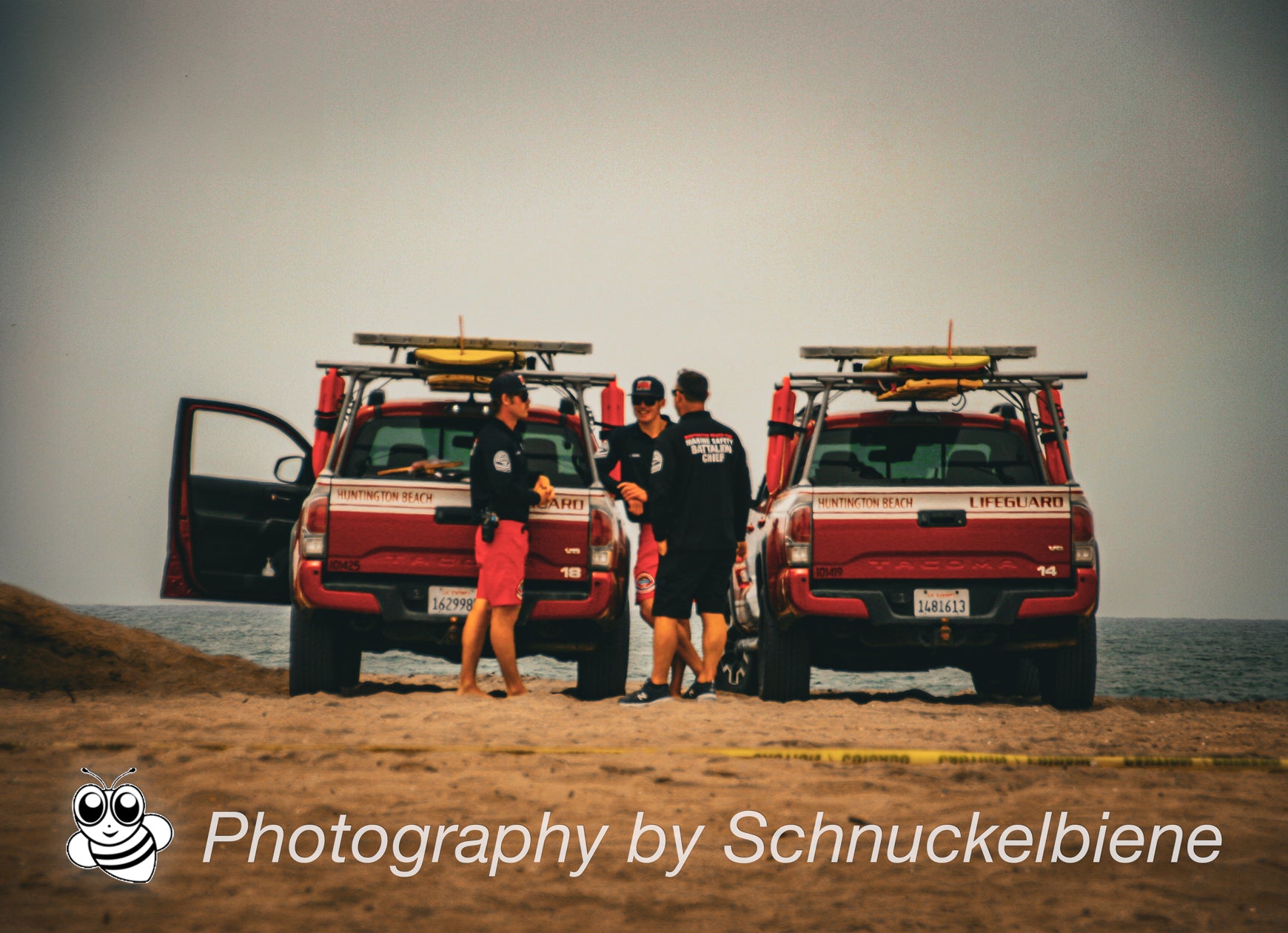 Photo of Huntington Beach lifeguards with jeeps on a cloudy day at the beach