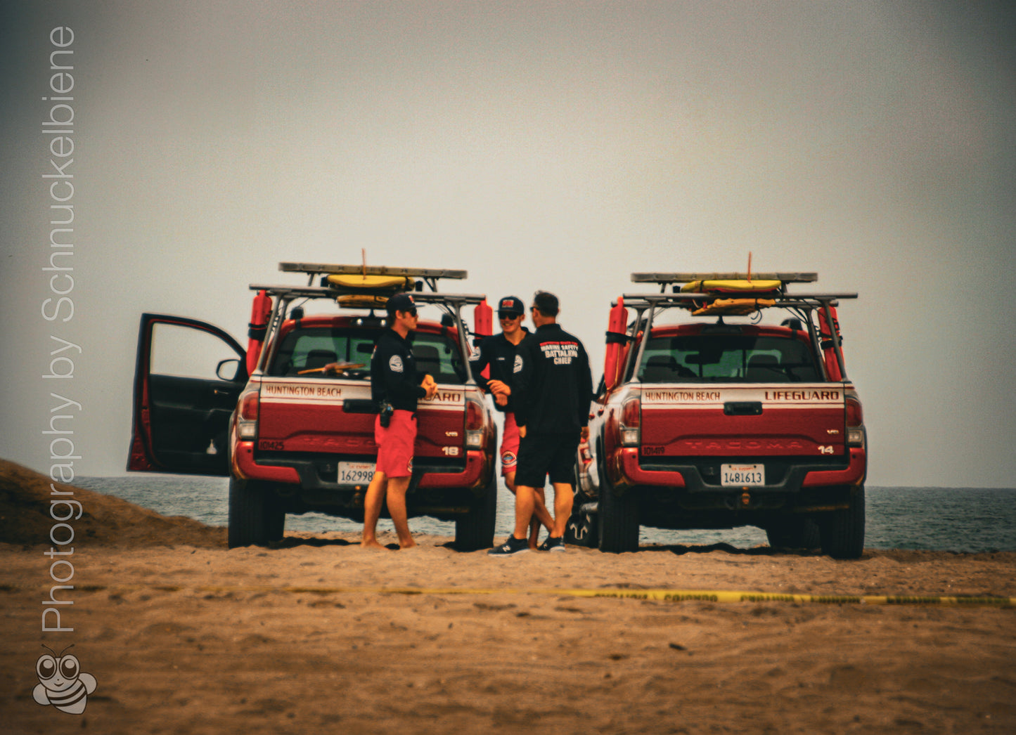 Photo of Huntington Beach lifeguards with jeeps on a cloudy day at the beach