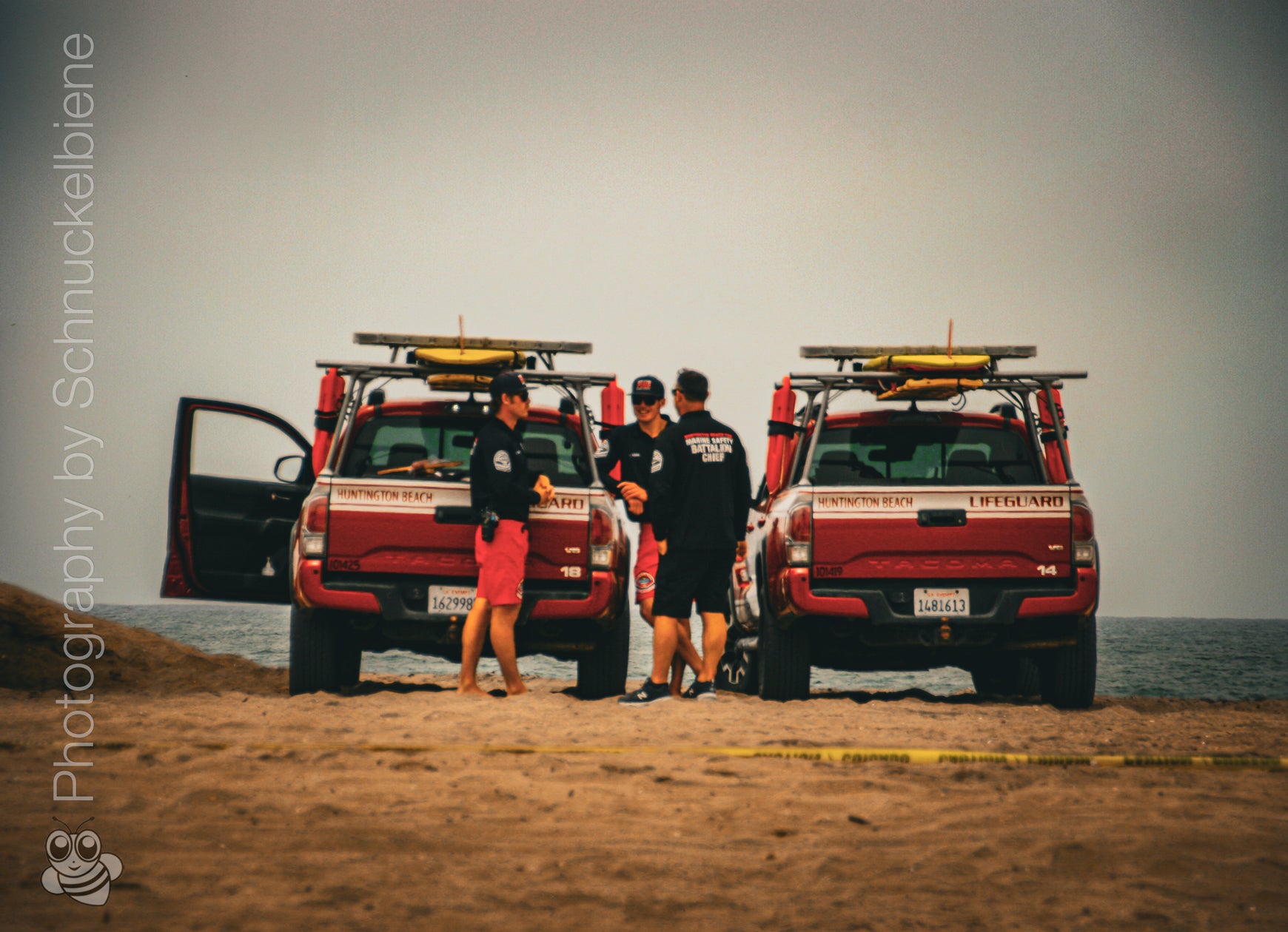 Photo of Huntington Beach lifeguards with jeeps on a cloudy day at the beach