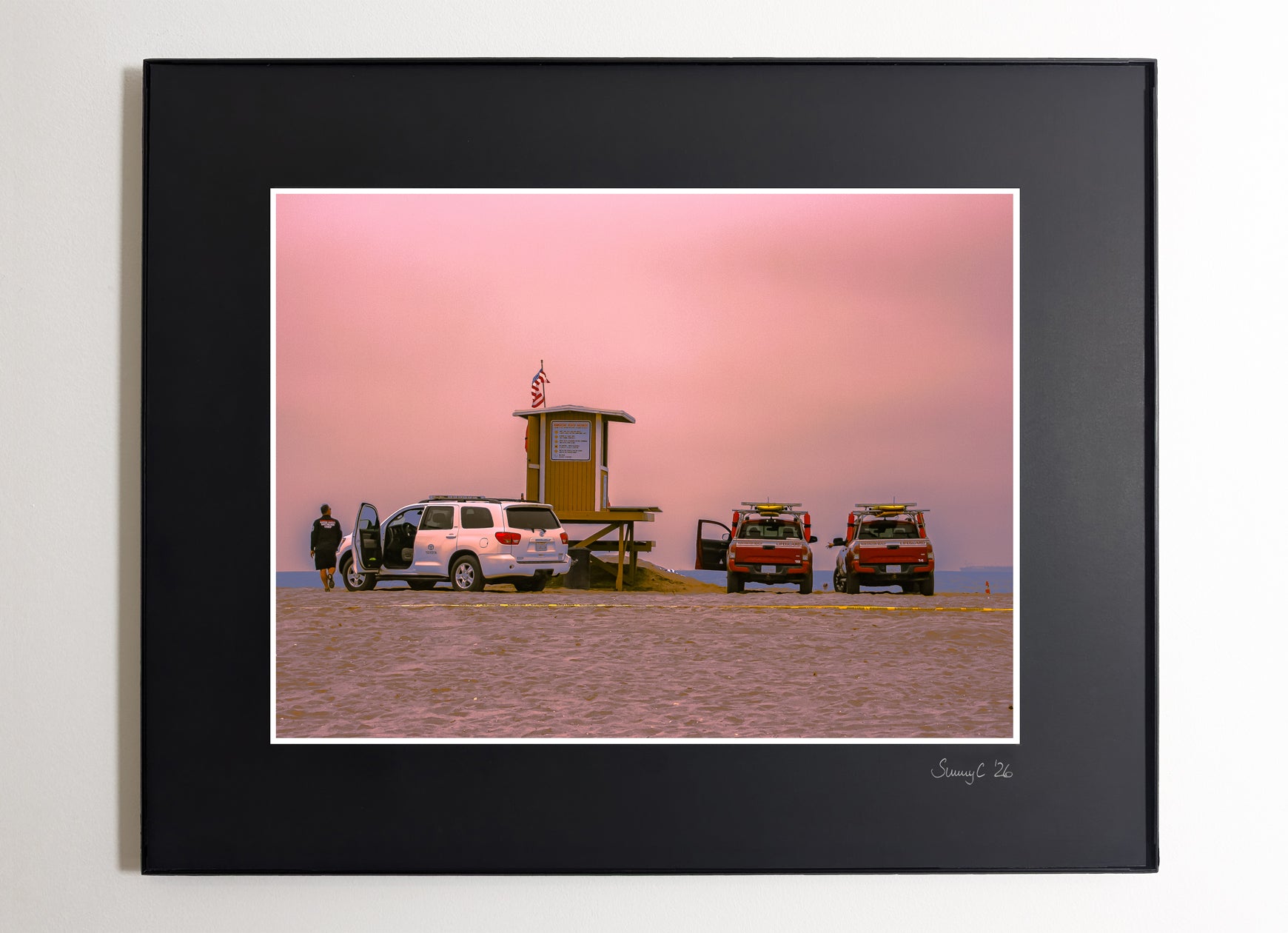 Huntington Beach lifeguard tower reunion under pink cloudy sky