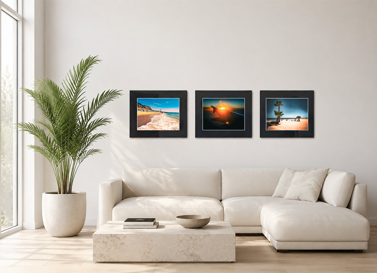 Three framed fine art photography prints displayed as a triptych gallery wall above a sofa with plant.