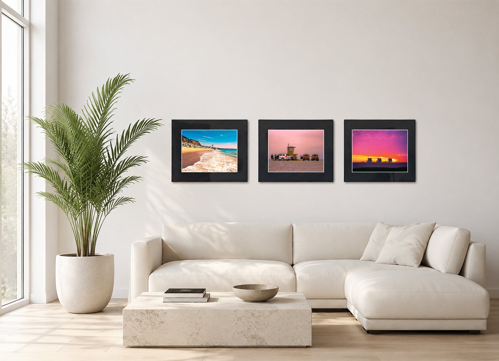 Three framed fine art photography prints displayed as a triptych gallery wall above a sofa with plant.