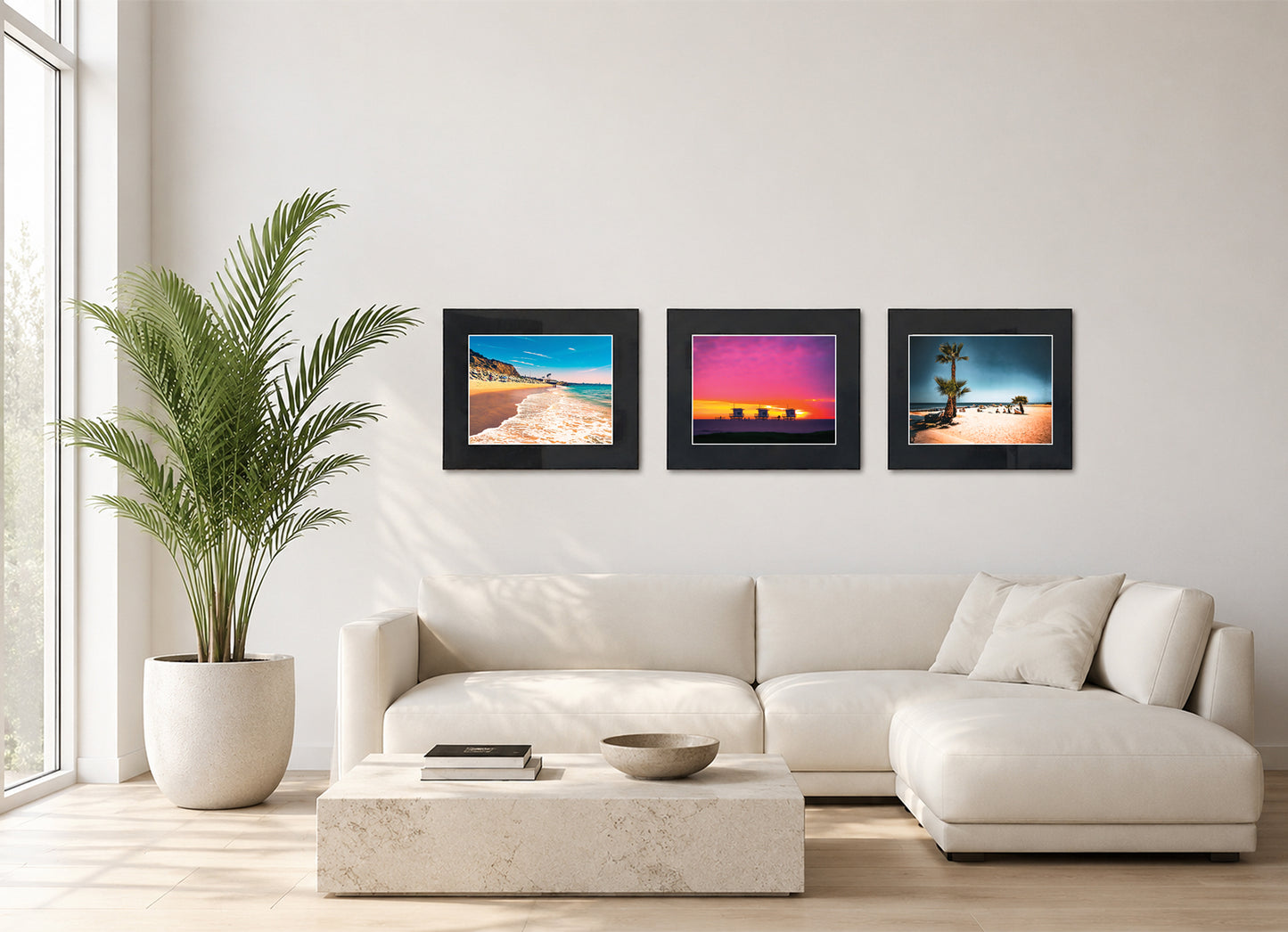 Three framed fine art photography prints displayed as a triptych gallery wall above a sofa with plant.