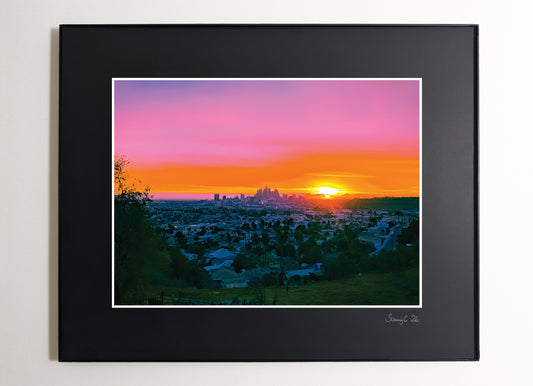 Framed photograph of the DTLA (Downtown Los Angeles) cityscape at sunset with vibrant pink and orange colors