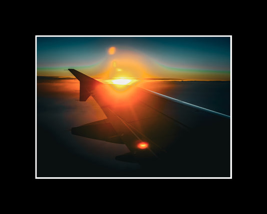 Airplane wing above the clouds during sunset on the way to Ibiza