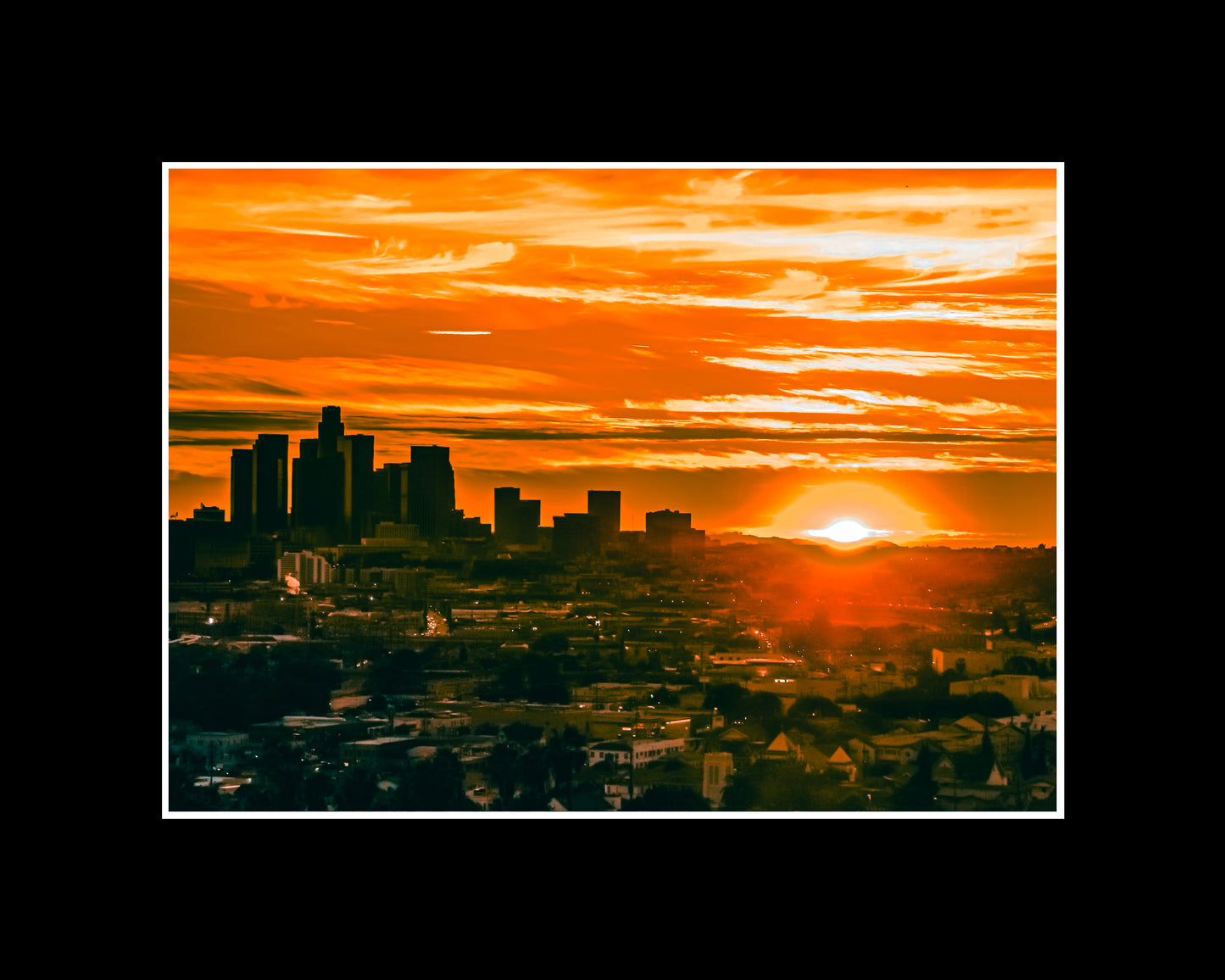 Downtown Los Angeles skyline glowing at sunset with warm golden light