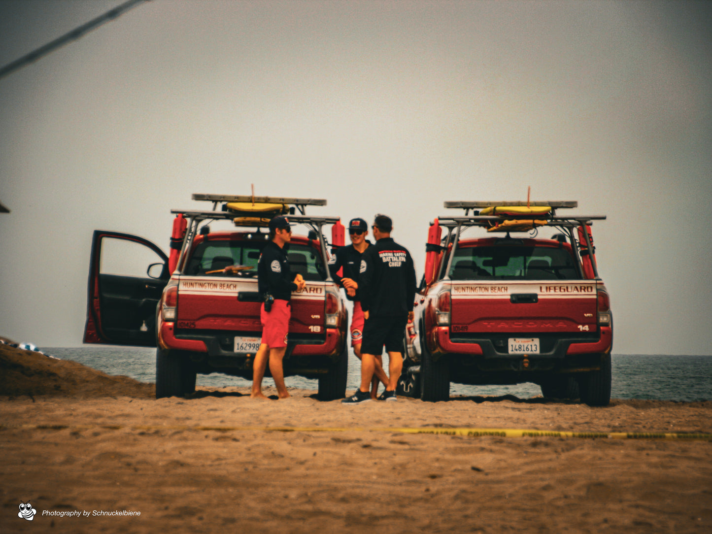 Photo of Huntington Beach lifeguards with jeeps on a cloudy day at the beach