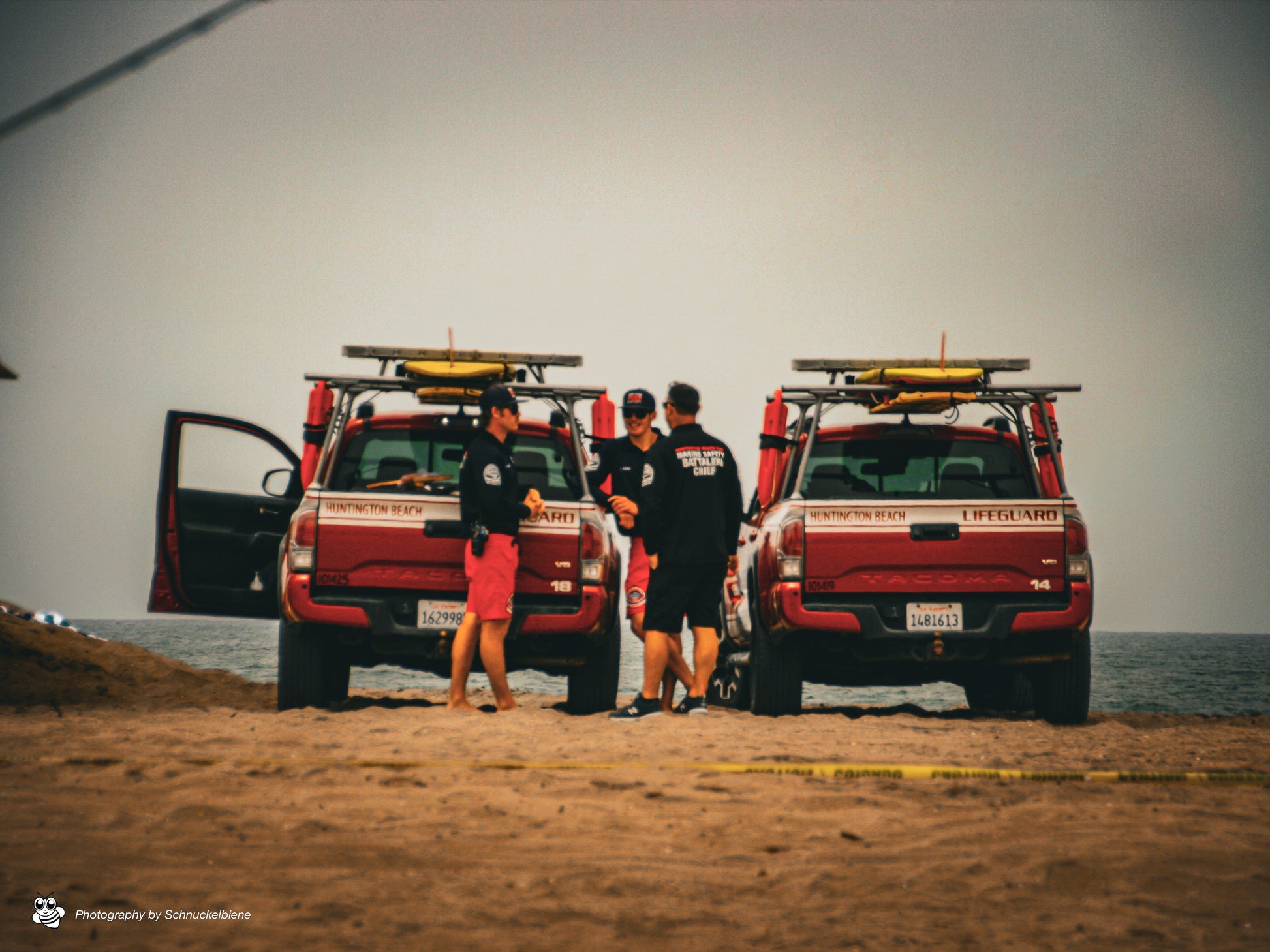 Photo of Huntington Beach lifeguards with jeeps on a cloudy day at the beach